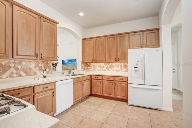 kitchen featuring tasteful backsplash, white appliances, sink, and light tile patterned floors