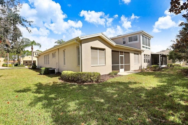 view of side of home with central AC unit, a lawn, and a sunroom