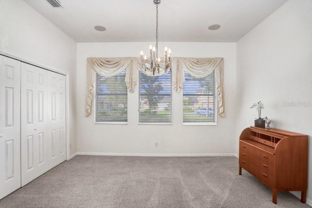 carpeted bedroom with a closet and an inviting chandelier