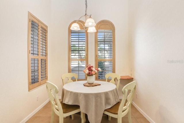 dining area with light tile patterned flooring and a chandelier