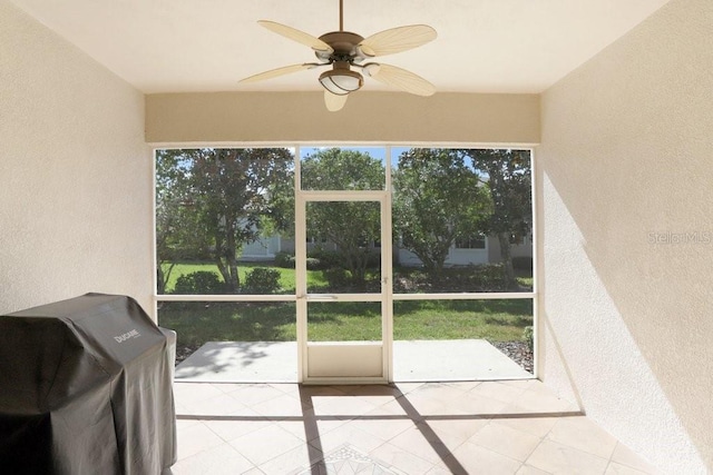 unfurnished sunroom featuring ceiling fan