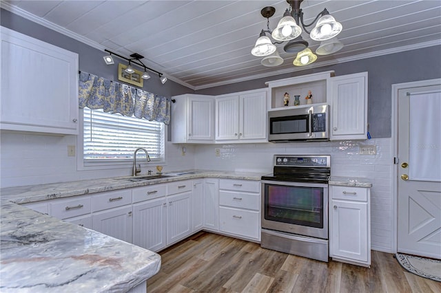 kitchen with stainless steel appliances, sink, ornamental molding, white cabinetry, and decorative light fixtures