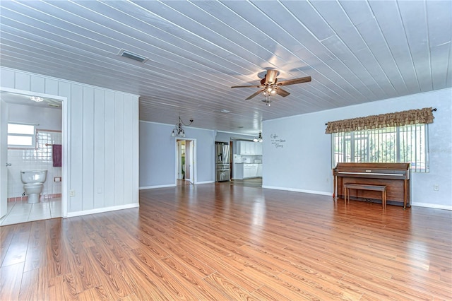 unfurnished living room with wood-type flooring, a healthy amount of sunlight, ceiling fan, and wood ceiling