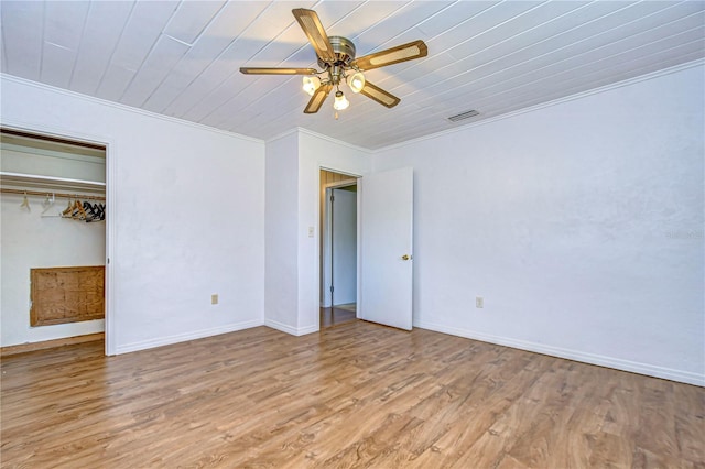 unfurnished bedroom featuring a closet, crown molding, light wood-type flooring, wooden ceiling, and ceiling fan