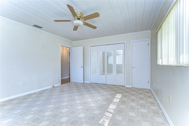 unfurnished bedroom featuring wooden ceiling, ceiling fan, a closet, and crown molding