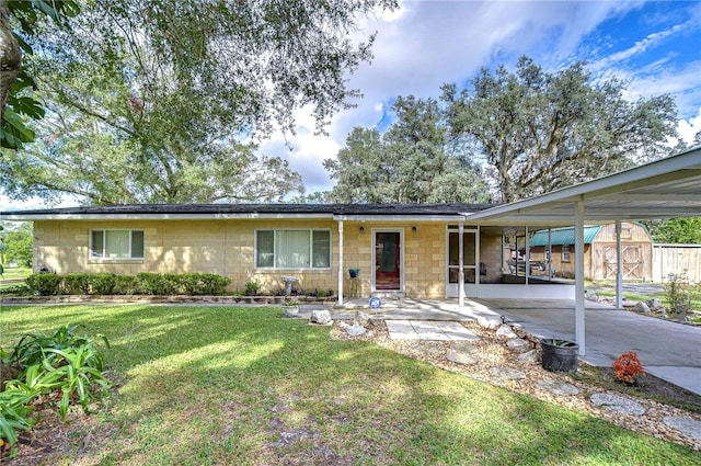 ranch-style home with a front yard and a patio