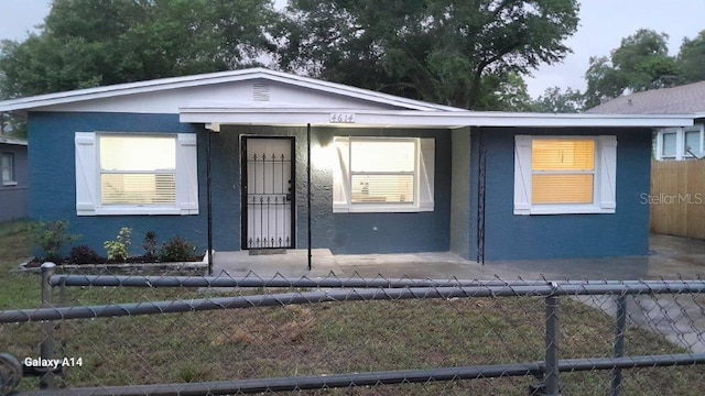 bungalow-style house with a fenced backyard and stucco siding