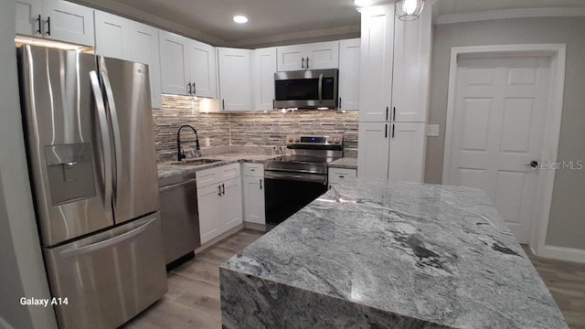 kitchen featuring light stone countertops, stainless steel appliances, light hardwood / wood-style floors, white cabinets, and sink