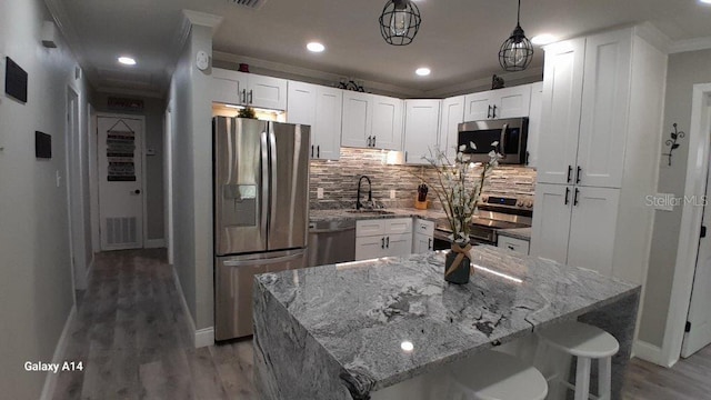 kitchen featuring appliances with stainless steel finishes, a center island, white cabinets, and sink