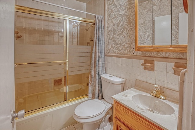 full bathroom featuring tile walls, combined bath / shower with glass door, vanity, and toilet