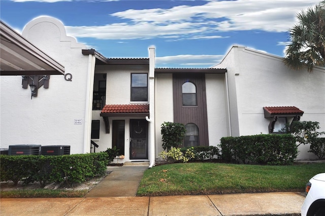 view of front facade with cooling unit and a front yard