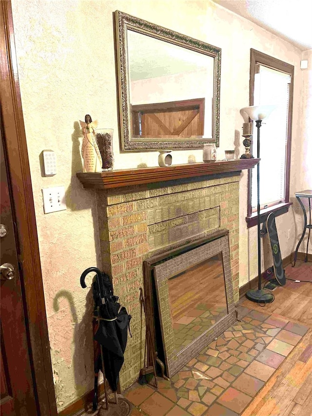 interior details featuring hardwood / wood-style floors and a brick fireplace