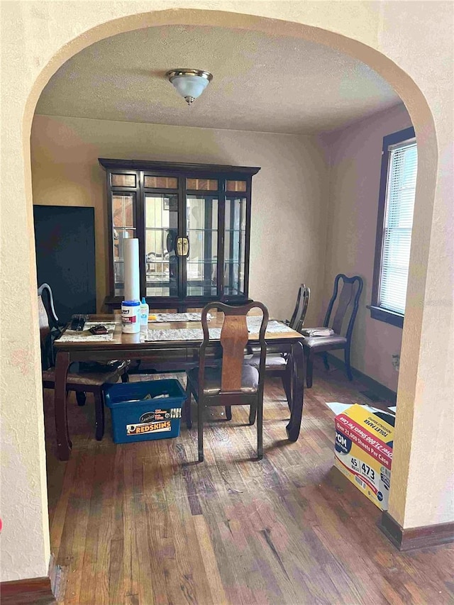 dining room featuring a textured ceiling and hardwood / wood-style flooring