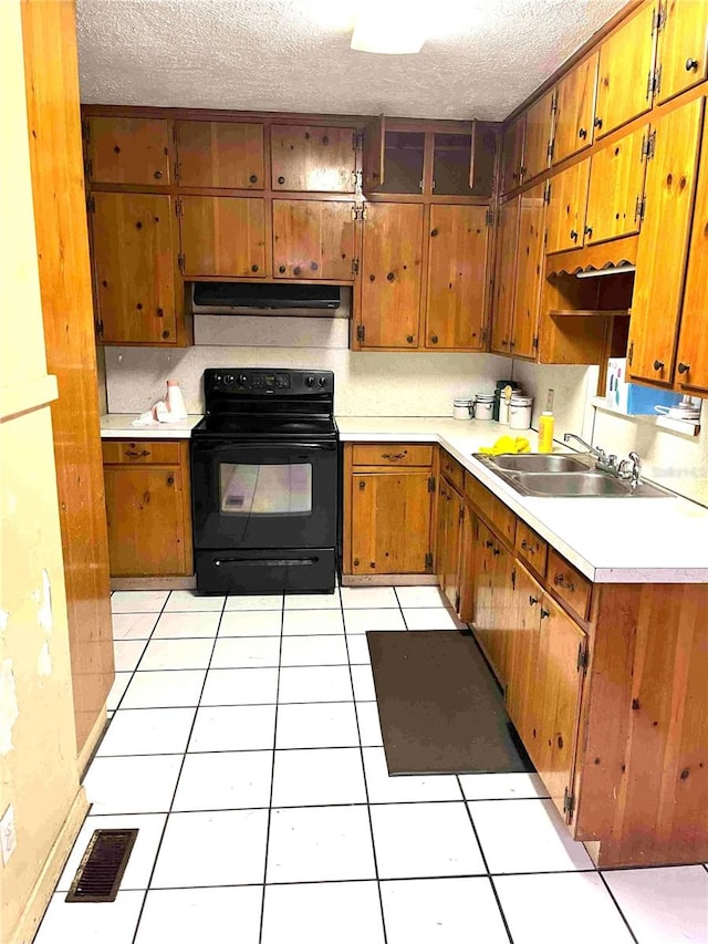 kitchen featuring black range with electric cooktop, sink, light tile patterned flooring, and a textured ceiling