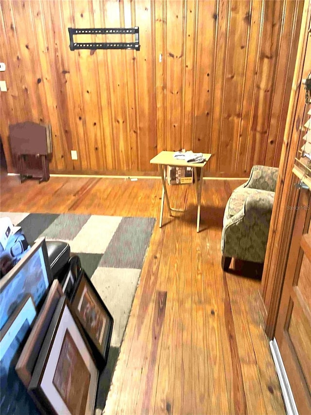 living area with wood walls and wood-type flooring