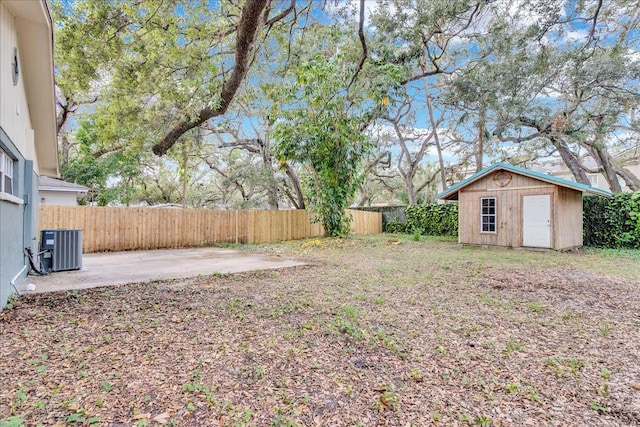 view of yard with central AC unit, a patio, and a storage shed