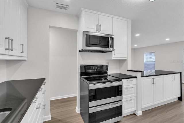 kitchen featuring white cabinetry, light wood-type flooring, and stainless steel appliances