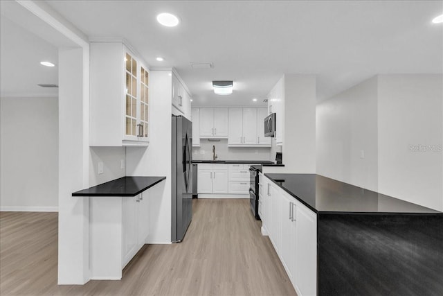 kitchen with white cabinetry, appliances with stainless steel finishes, light hardwood / wood-style floors, and sink