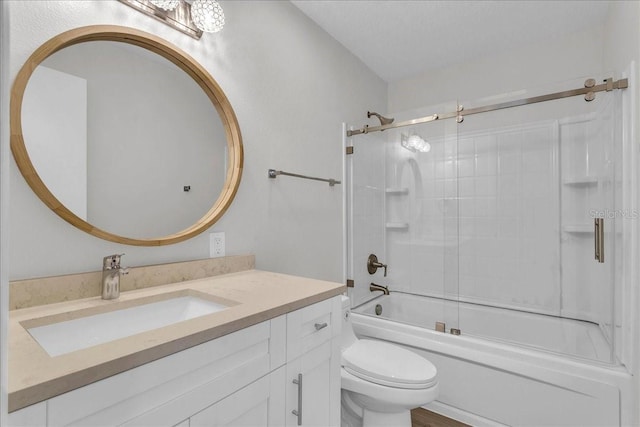 full bathroom featuring vanity, combined bath / shower with glass door, and toilet