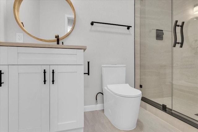 bathroom featuring toilet, vanity, hardwood / wood-style flooring, and a shower with shower door