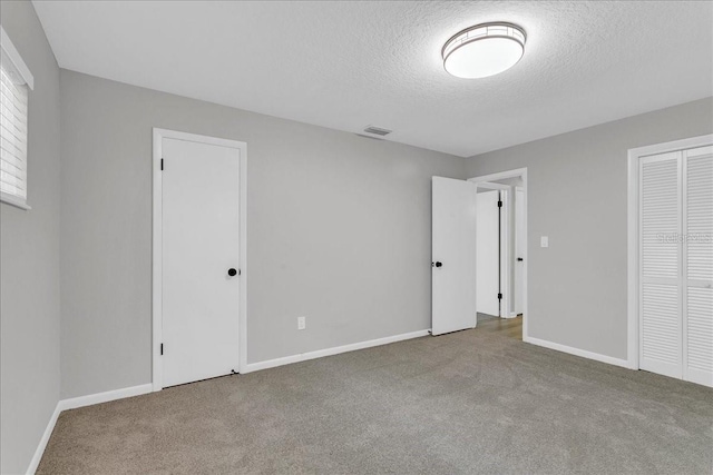 unfurnished bedroom featuring a textured ceiling and carpet floors