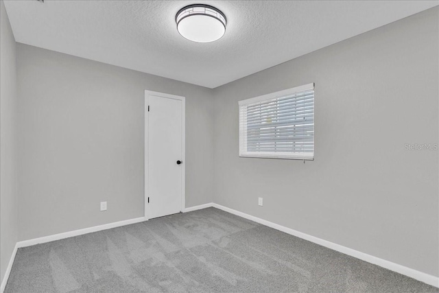 carpeted spare room featuring a textured ceiling