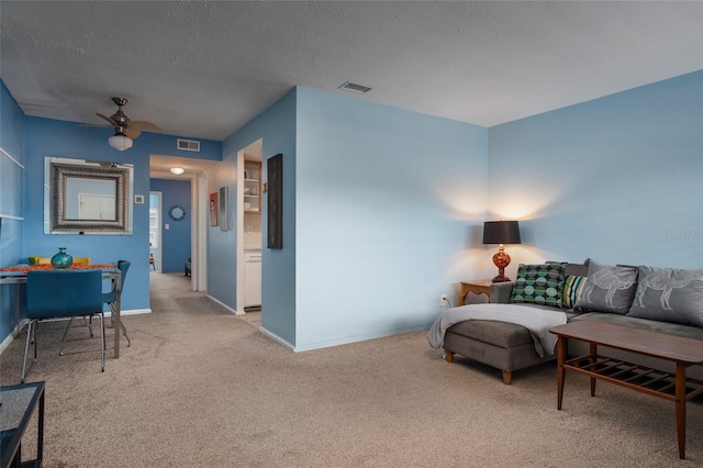 carpeted living room with a textured ceiling and ceiling fan