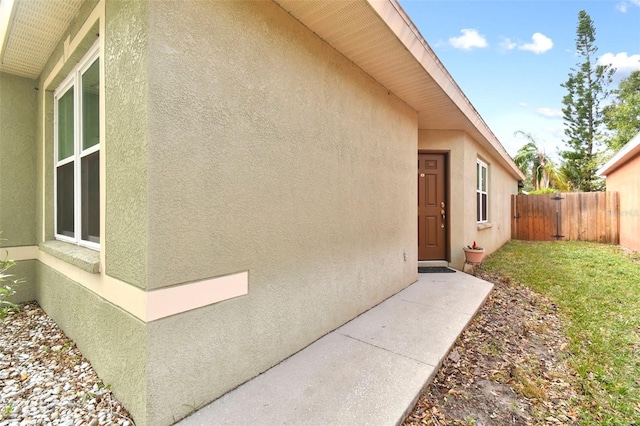 property entrance with a lawn