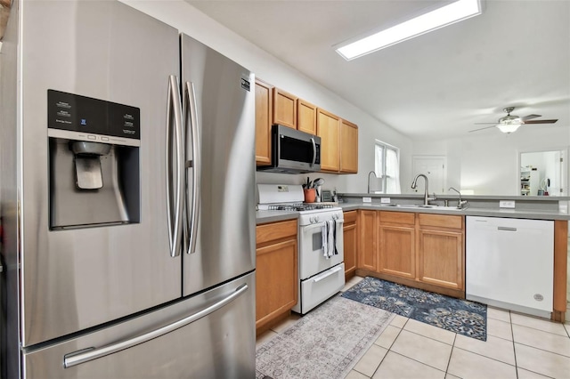 kitchen featuring stainless steel appliances, sink, ceiling fan, and light tile patterned floors