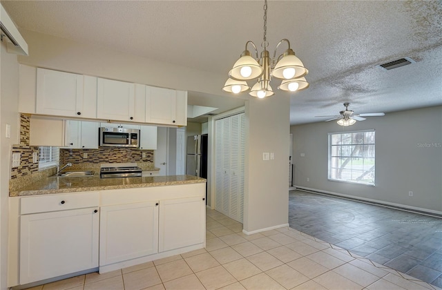 18138 Lake Worth Blvd, Port Charlotte, FL 33948 - kitchen featuring appliances with stainless steel finishes, a peninsula, a chandelier, decorative backsplash, and a sink