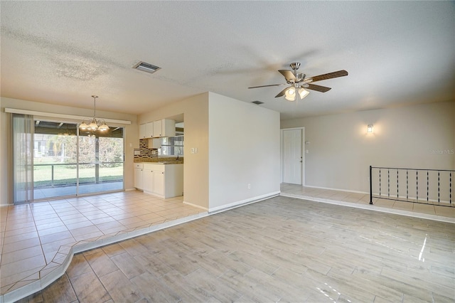 18138 Lake Worth Blvd, Port Charlotte, FL 33948 - unfurnished living room featuring a chandelier, ceiling fan, light wood finished floors, a textured ceiling, and baseboards