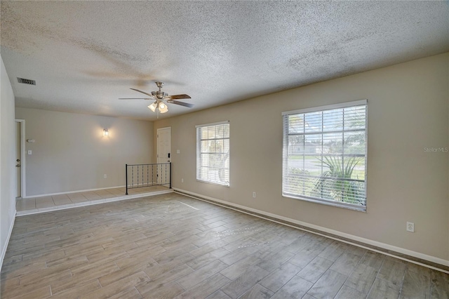 18138 Lake Worth Blvd, Port Charlotte, FL 33948 - unfurnished room with wood finished floors, a ceiling fan, a textured ceiling, and baseboards