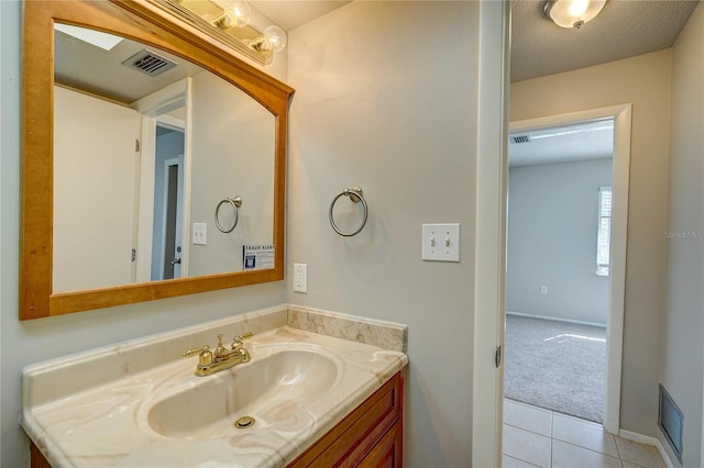 bathroom featuring vanity, tile patterned flooring, and a textured ceiling