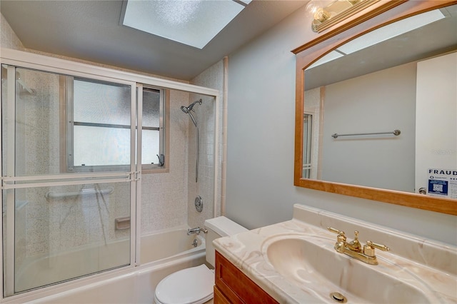 full bathroom featuring vanity, combined bath / shower with glass door, and toilet