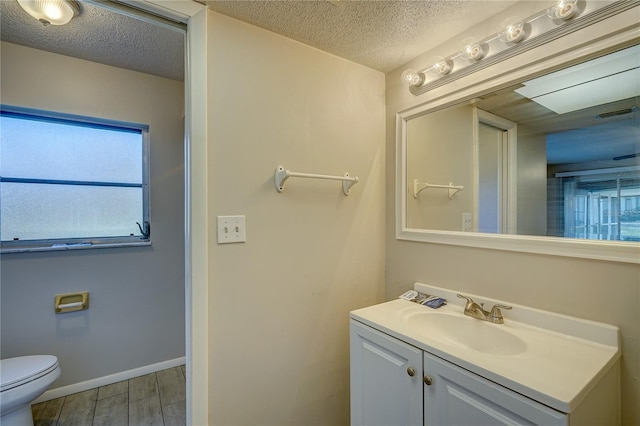 18138 Lake Worth Blvd, Port Charlotte, FL 33948 - bathroom with a textured ceiling, vanity, wood finished floors, and toilet