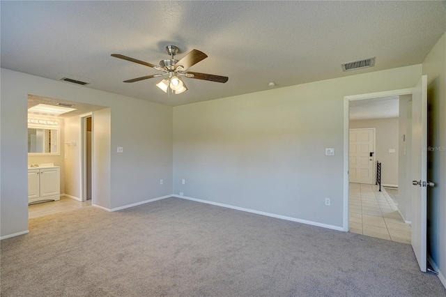 interior space featuring a textured ceiling, light colored carpet, and ceiling fan