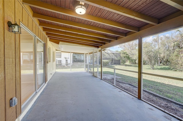 unfurnished sunroom featuring beamed ceiling