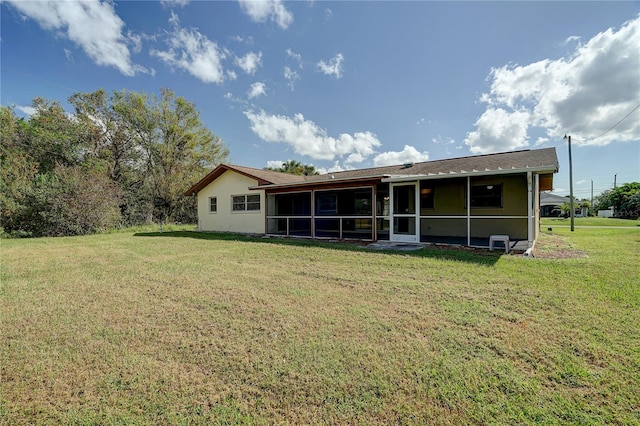 18138 Lake Worth Blvd, Port Charlotte, FL 33948 - back of house featuring a sunroom, a lawn, and stucco siding