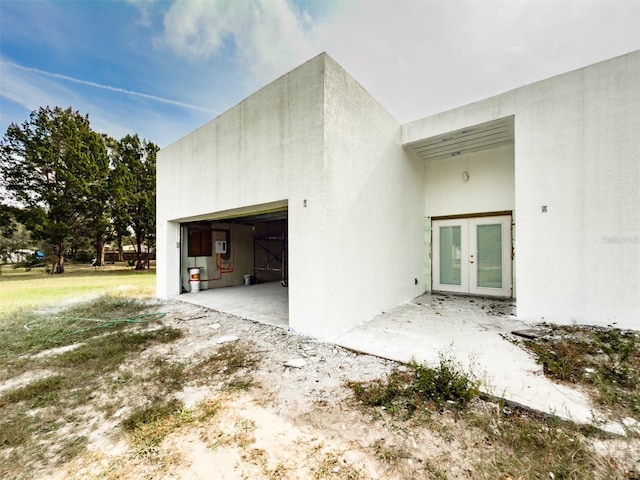 view of side of home featuring french doors and a garage