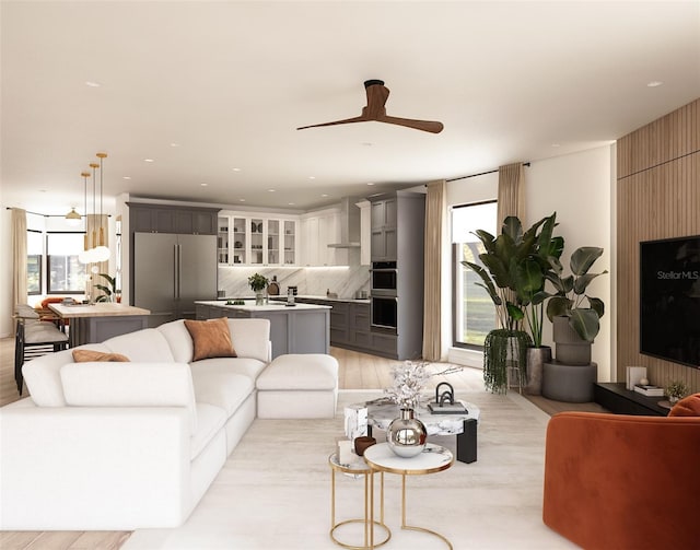 living room with ceiling fan and light hardwood / wood-style flooring