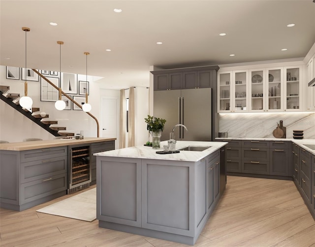 7176 S Shore Dr, South Pasadena, FL 33707 - kitchen featuring wine cooler, freestanding refrigerator, a sink, gray cabinetry, and a kitchen island with sink