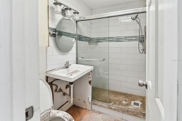 bathroom with toilet, vanity, an enclosed shower, and tile walls