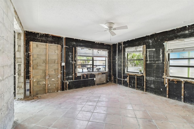 interior space with ceiling fan and a textured ceiling