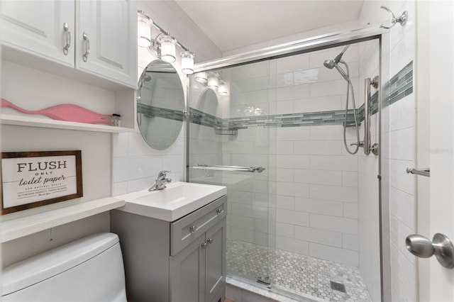 bathroom featuring toilet, vanity, decorative backsplash, and walk in shower