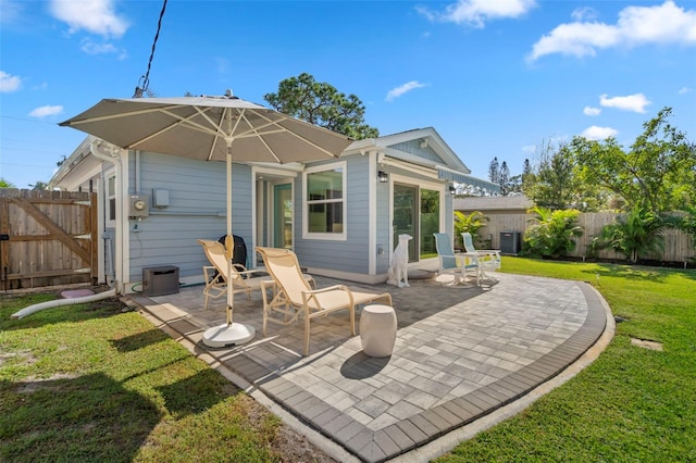 rear view of house featuring a patio and a yard