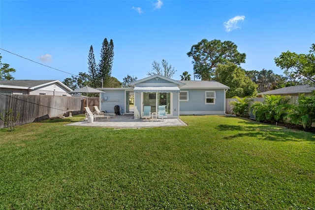 back of house with a yard and a patio