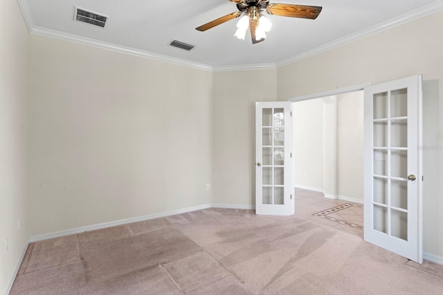 carpeted spare room featuring ceiling fan, ornamental molding, and french doors