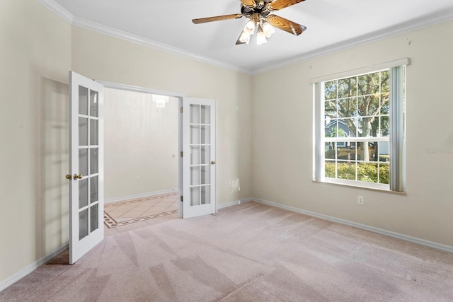 carpeted spare room featuring french doors, ceiling fan, and crown molding