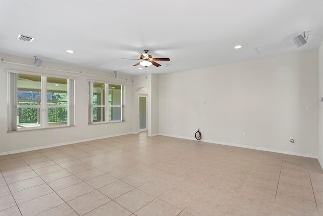 empty room with ceiling fan and light tile patterned flooring