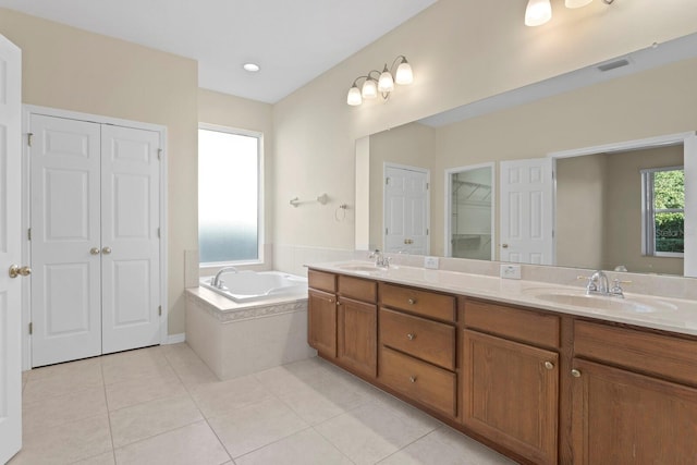 bathroom featuring tiled tub, tile patterned flooring, and vanity